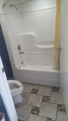 a bathroom with a white tub and a toilet at Travel Inn in Sharonville