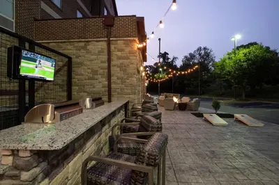a bar with chairs and a tv on a brick building at Homewood Suites Cincinnati Airport South-Florence in Florence