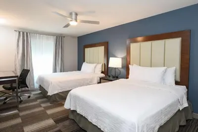 a hotel room with two beds and a desk at Homewood Suites Cincinnati Airport South-Florence in Florence