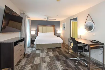 a hotel room with a bed and a desk and a computer at Homewood Suites Cincinnati Airport South-Florence in Florence
