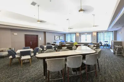 a waiting room with tables and chairs in a building at Homewood Suites Cincinnati Airport South-Florence in Florence