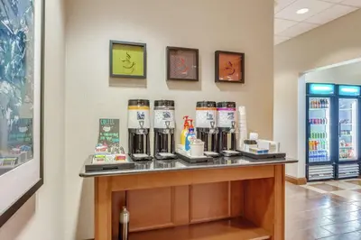 a counter in a store with a bunch of drinks at Hampton Inn Auburn in Auburn