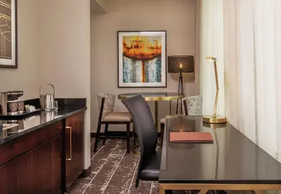a hotel room with a desk and a table with chairs at Doubletree By Hilton Youngstown Downtown in Youngstown