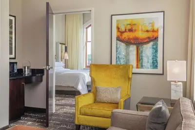a hotel room with a bed and a yellow chair at Doubletree By Hilton Youngstown Downtown in Youngstown