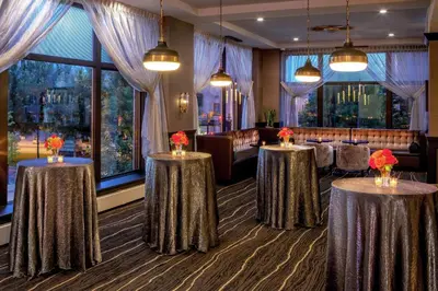 a dining room with two tables with flowers on them at Doubletree By Hilton Youngstown Downtown in Youngstown