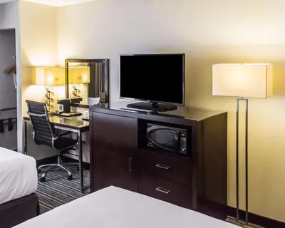 a hotel room with a bed and a desk with a television at Quality Inn Streetsboro - Kent in Streetsboro