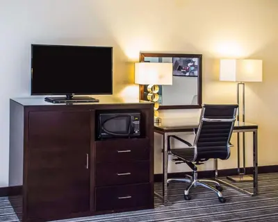 a hotel room with a desk with a television and a chair at Quality Inn Streetsboro - Kent in Streetsboro