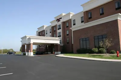 a building with a red fire hydrant in front of it at Hampton Inn Stow in Stow