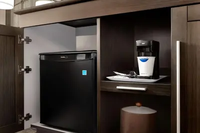 a kitchen with a small refrigerator and a coffee maker at Hampton Inn Stow in Stow