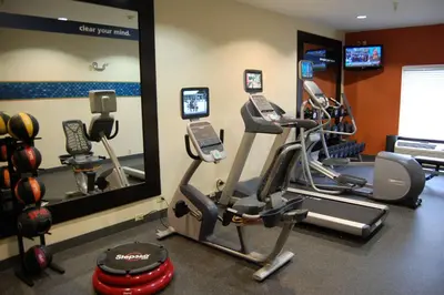 a gym with two exercise bikes and a mirror at Hampton Inn Stow in Stow