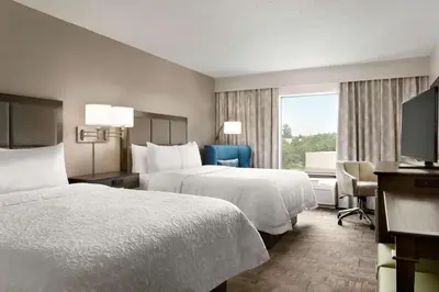 a hotel room with two beds and a window at Hampton Inn Stow in Stow