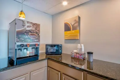 a kitchen with a counter with a microwave and a refrigerator at Motel 6-Springfield, OH in Springfield