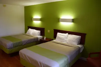 two beds in a hotel room with green walls at Motel 6-Springfield, OH in Springfield