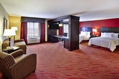a hotel room with two beds and a desk at Hampton Inn Ft Wayne in Fort Wayne