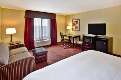 a hotel room with a bed and a flat screen tv at Hampton Inn Ft Wayne in Fort Wayne