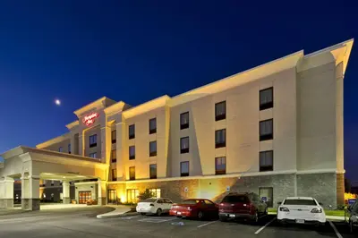 a hotel with cars parked in a parking lot at Hampton Inn Ft Wayne in Fort Wayne