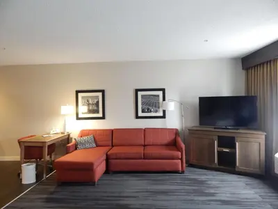 a living room with a red couch and a flat screen tv at Hampton Inn Heath in Heath