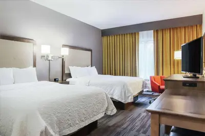 a hotel room with two beds and a flat screen tv at Hampton Inn Heath in Heath