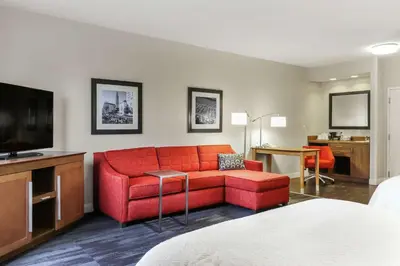 a living room with a red couch and a television at Hampton Inn Heath in Heath