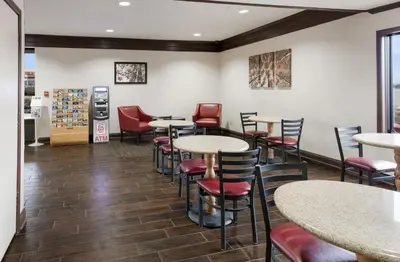 a restaurant with tables and chairs in a room at Red Roof Inn Fort Wayne in Fort Wayne