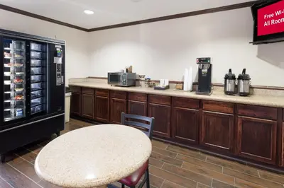 a coffee shop with a table and a counter at Red Roof Inn Fort Wayne in Fort Wayne