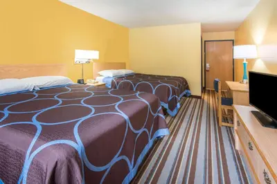 a hotel room with two beds and a flat screen tv at Super 8 by Wyndham Medina in Medina