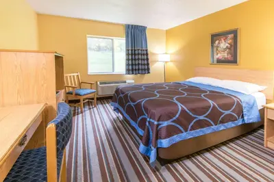 a hotel room with a bed and a desk at Super 8 by Wyndham Medina in Medina