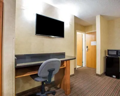 a room with a desk with a chair and a television at Quality Inn & Suites North-Polaris in Worthington