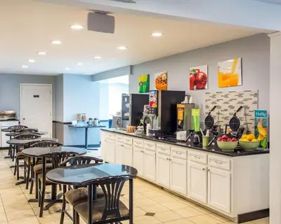 a restaurant with tables and chairs and a counter at Quality Inn & Suites North-Polaris in Worthington