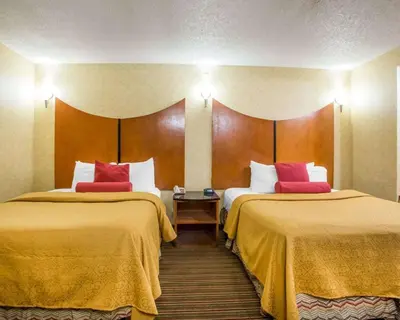a hotel room with two beds with yellow and red pillows at Quality Inn & Suites North-Polaris in Worthington