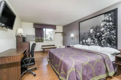 a hotel room with a bed and a desk at Super 8 by Wyndham Zanesville in Zanesville