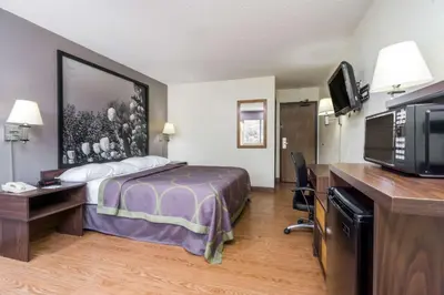 a hotel room with a bed and a flat screen tv at Super 8 by Wyndham Zanesville in Zanesville