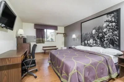 a hotel room with a bed and a desk at Super 8 by Wyndham Zanesville in Zanesville
