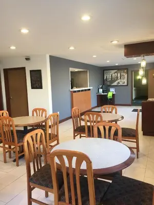 a restaurant with tables and chairs and a kitchen at Super 8 by Wyndham Zanesville in Zanesville