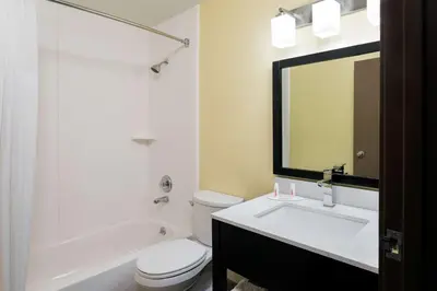 a bathroom with a toilet and a sink and a mirror at Super 8 by Wyndham Marietta in Marietta