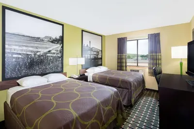a hotel room with two beds and a flat screen tv at Super 8 by Wyndham Marietta in Marietta