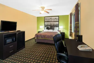 a hotel room with a bed and a flat screen tv at Super 8 by Wyndham Marietta in Marietta
