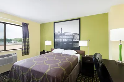 a hotel room with a bed and a large window at Super 8 by Wyndham Marietta in Marietta