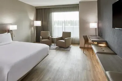 a hotel room with a bed and a desk and chairs at AC Hotel by Marriott Cleveland Beachwood in Beachwood