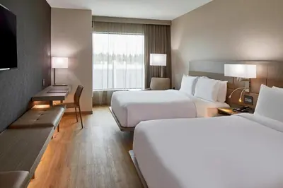a hotel room with two beds and a window at AC Hotel by Marriott Cleveland Beachwood in Beachwood