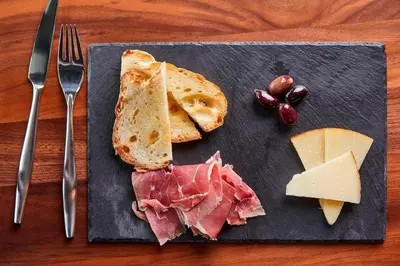 a plate of food with meat cheese and bread at AC Hotel by Marriott Cleveland Beachwood in Beachwood