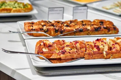a buffet with several different types of food on plates at AC Hotel by Marriott Cleveland Beachwood in Beachwood