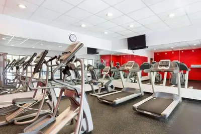 a gym with several tread machines in a room at Radisson Akron-Fairlawn Copley in Fairlawn