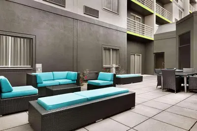 a lobby of a building with blue chairs and tables at Radisson Akron-Fairlawn Copley in Fairlawn