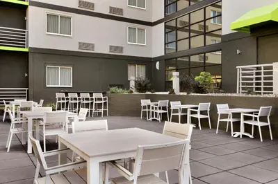 a patio with white tables and chairs and a building at Radisson Akron-Fairlawn Copley in Fairlawn