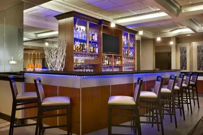 a bar with a row of chairs in a room at Radisson Akron-Fairlawn Copley in Fairlawn