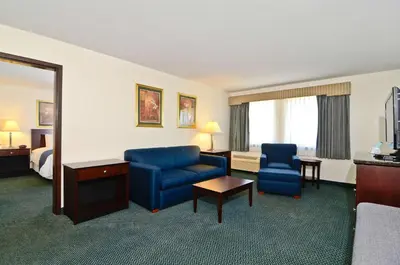 a hotel room with a bed and a blue couch and chair at Best Western Gas City in Gas City