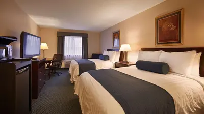 a hotel room with two beds and a flat screen tv at Best Western Gas City in Gas City