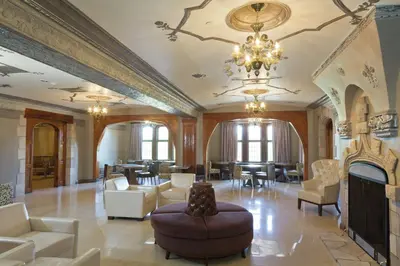 a large living room with a chandelier and a fireplace at The Tudor Arms Hotel Cleveland - a DoubleTree by Hilton in Cleveland