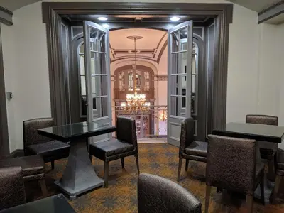 a dining room with tables and chairs and a chandelier at The Tudor Arms Hotel Cleveland - a DoubleTree by Hilton in Cleveland